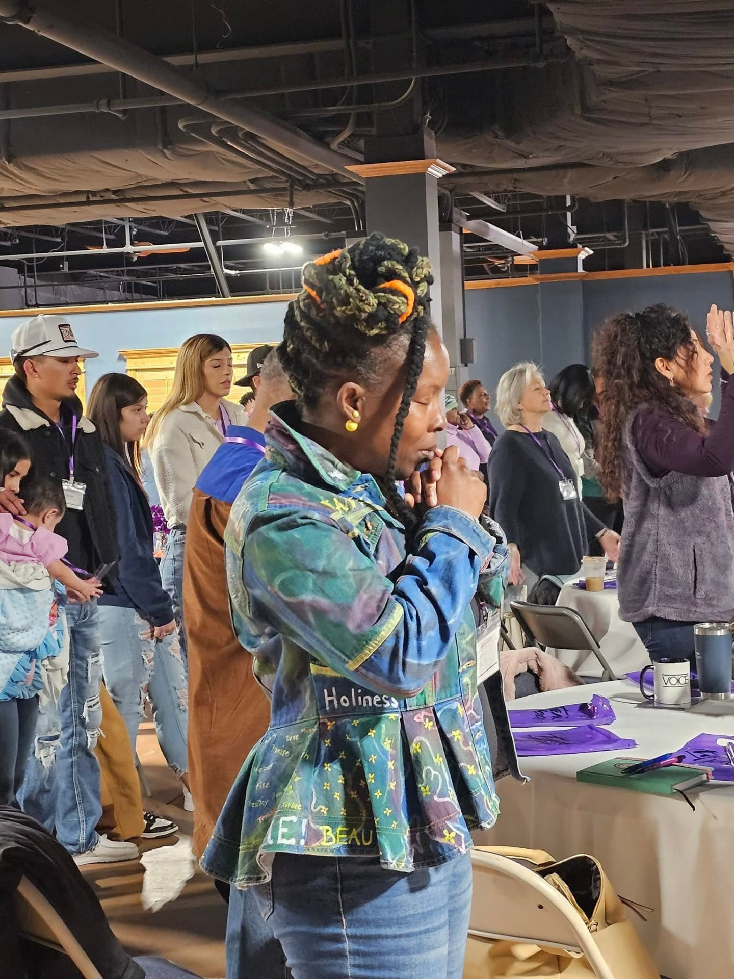 Women worshipping together in prayer at a New Era Women gathering